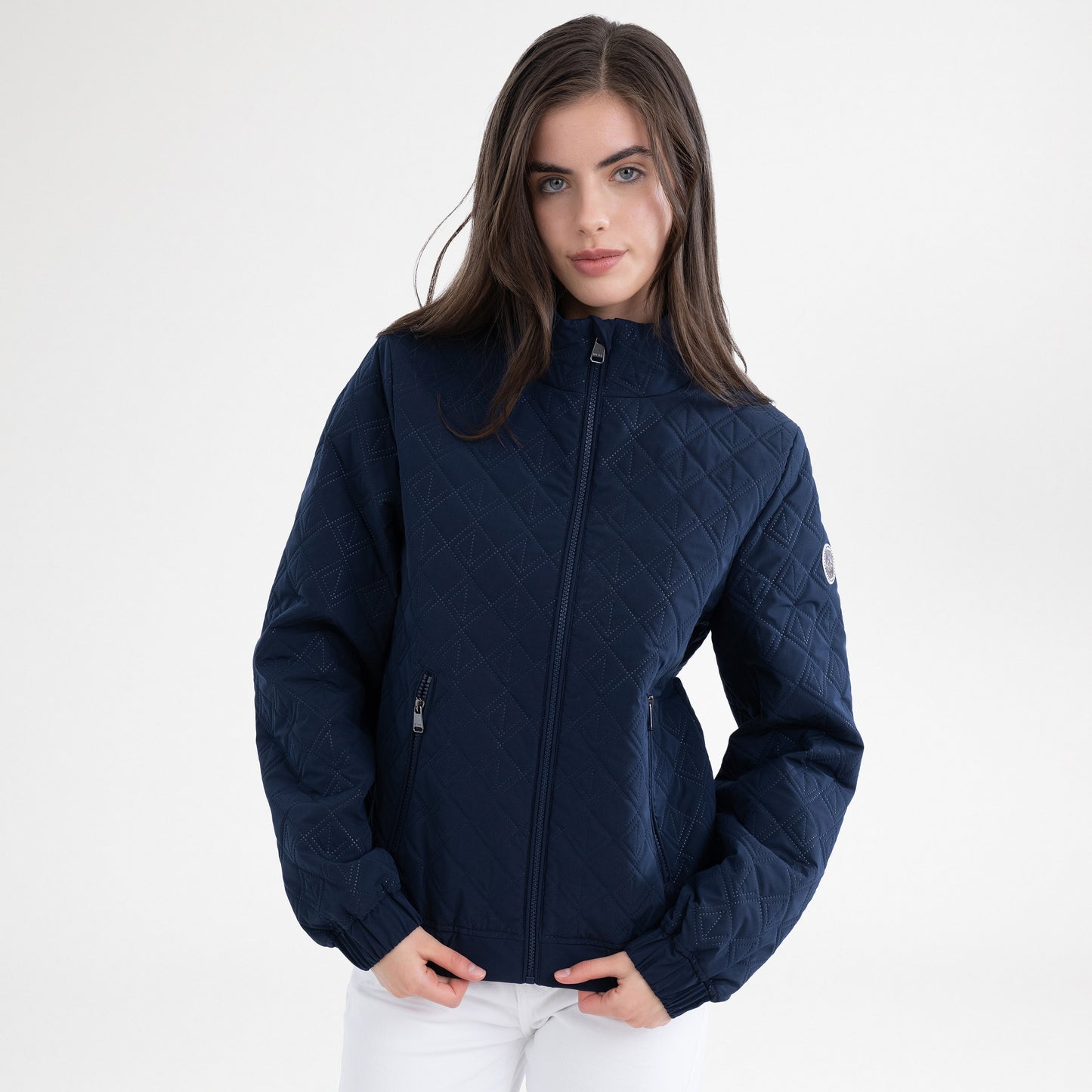 Girl wearing a navy jacket and white breeches on a white background