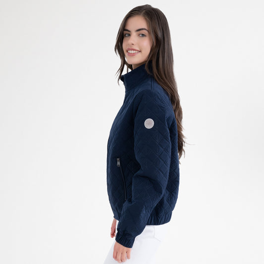 Girl wearing a navy jacket and white breeches on a white background
