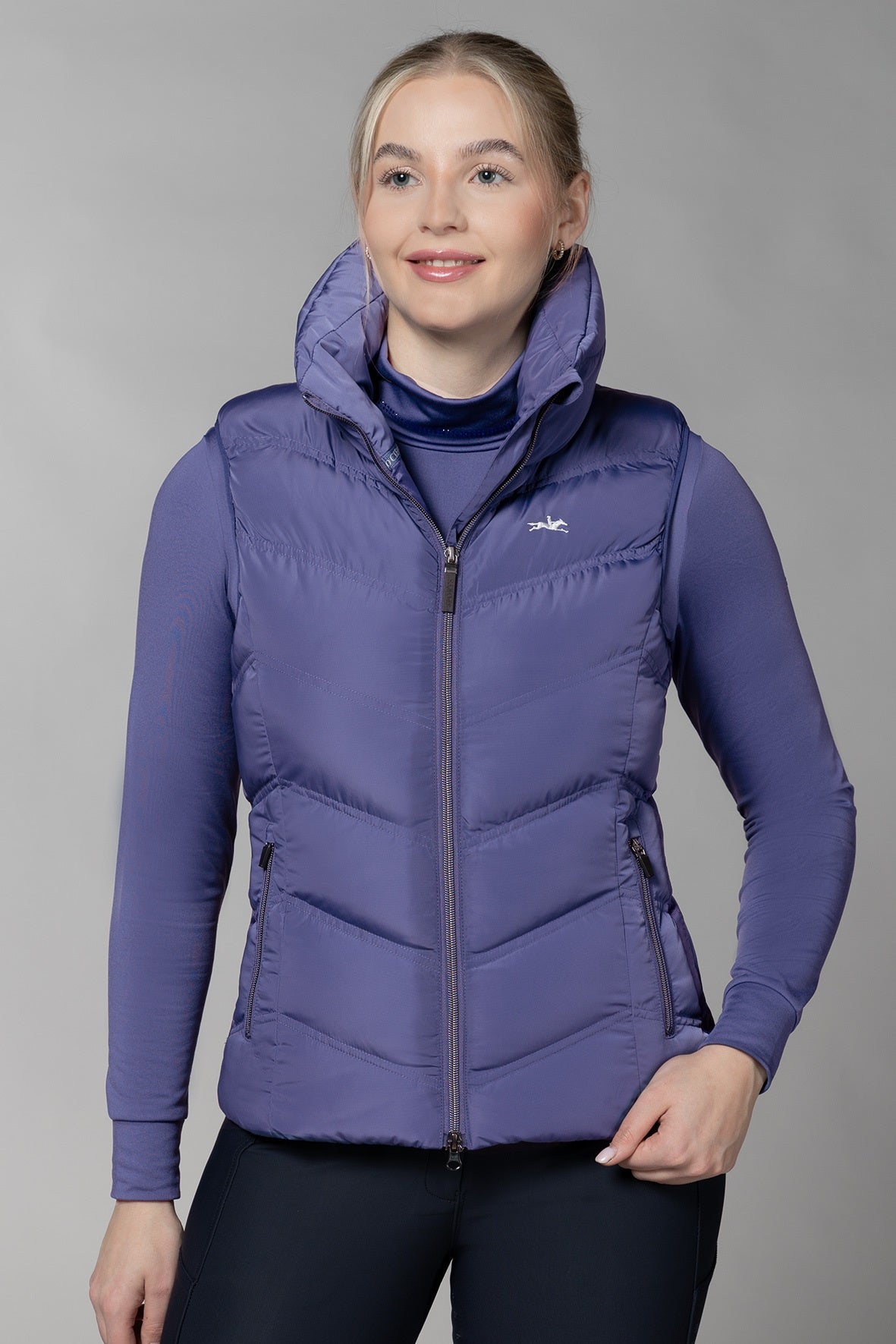Ink blue gilet on a model with a grey background