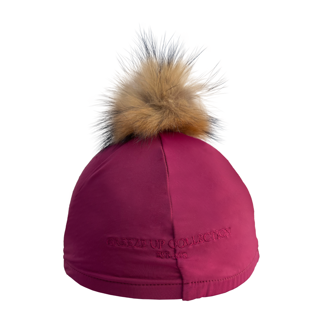 Pink hat silk with a fur pom-pom on a white background