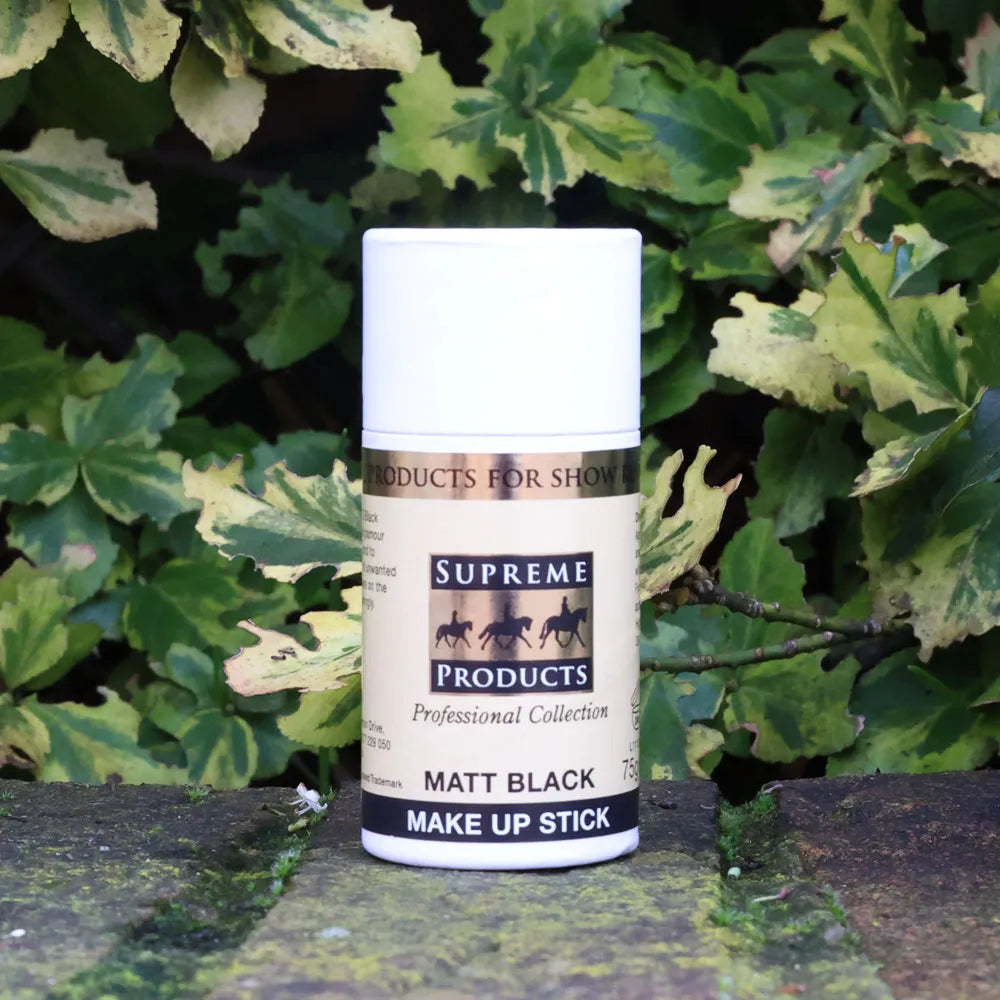 Makeup stick with 'Supreme Products' branding against a leafy green background