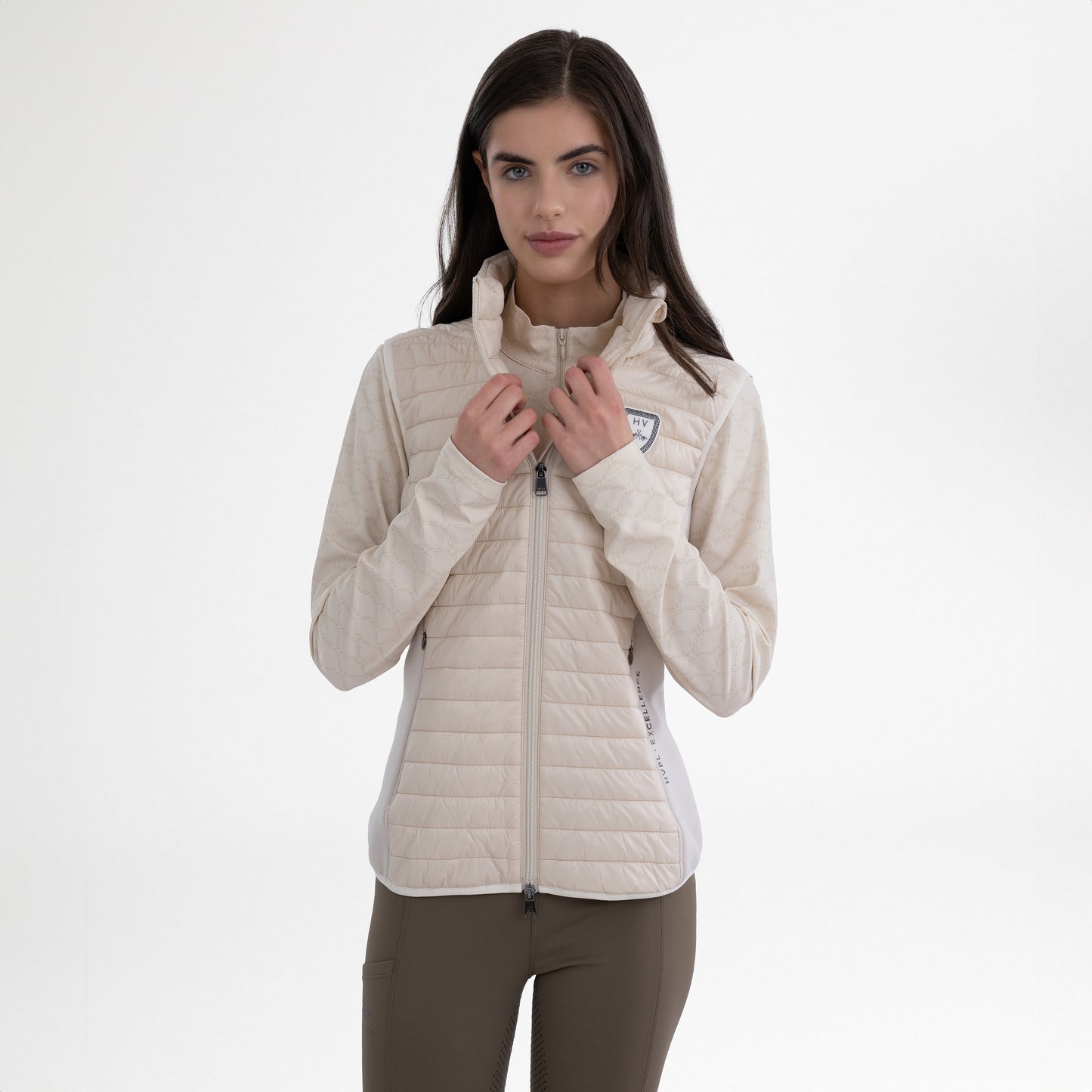Girl wearing a cream gilet and brown breeches on a white background