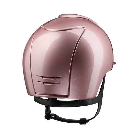 Pink riding helmet with black strap on a white background