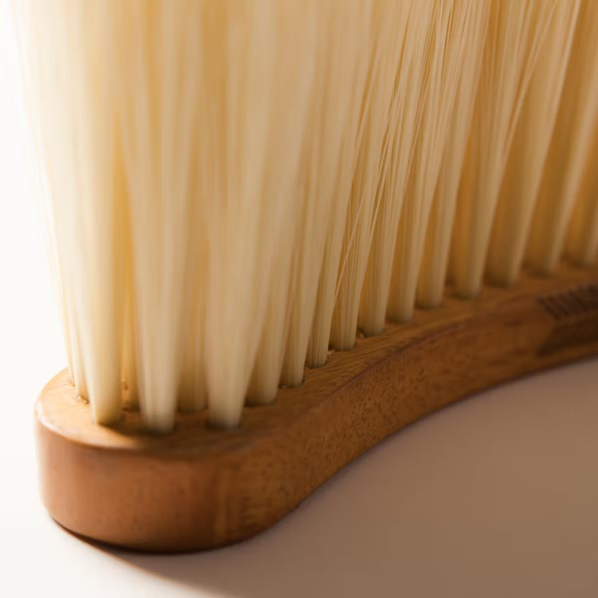 Close-up of a wooden brush with bristles on a white background