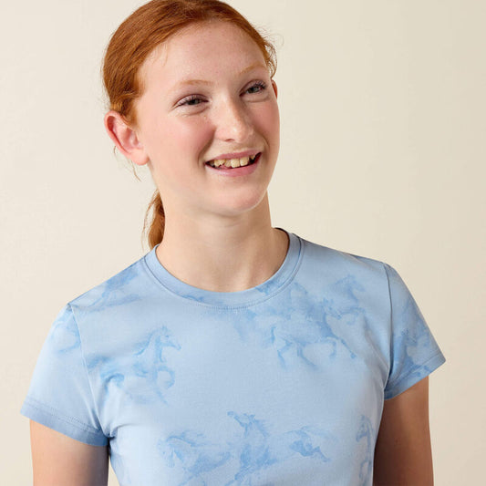 Person wearing a light blue t-shirt with horse patterns on a plain background
