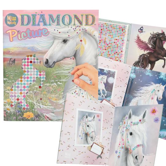Diamond painting kit with unicorn designs and a hand holding a diamond.