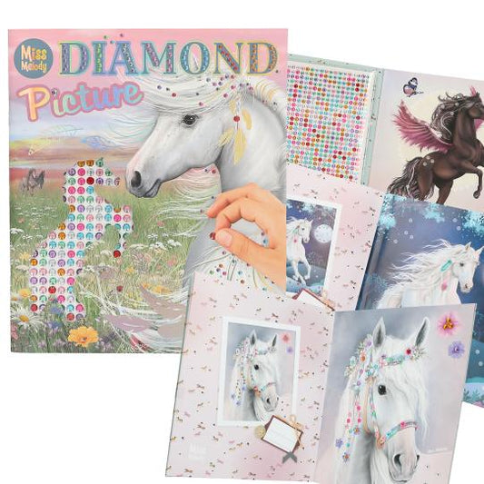 Diamond painting kit with unicorn designs and a hand holding a diamond.