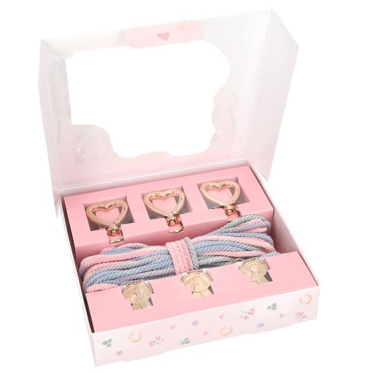Set of hair ties with heart-shaped clips in a pink box on a white background