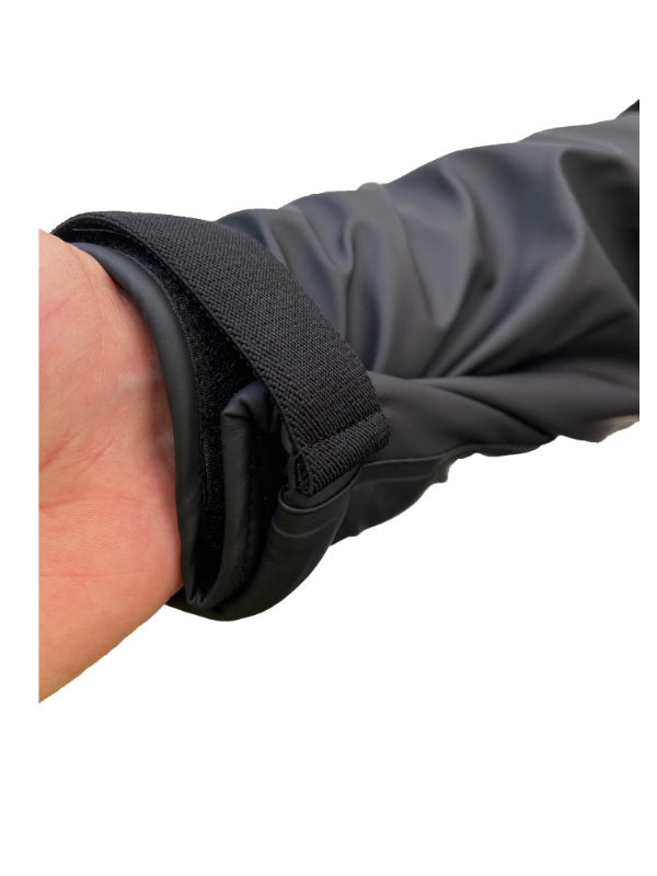 Close-up of a person wearing a black sleeve with a black wristband on a white background