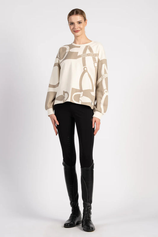 Woman wearing a beige sweater with equestrian motif on a white background