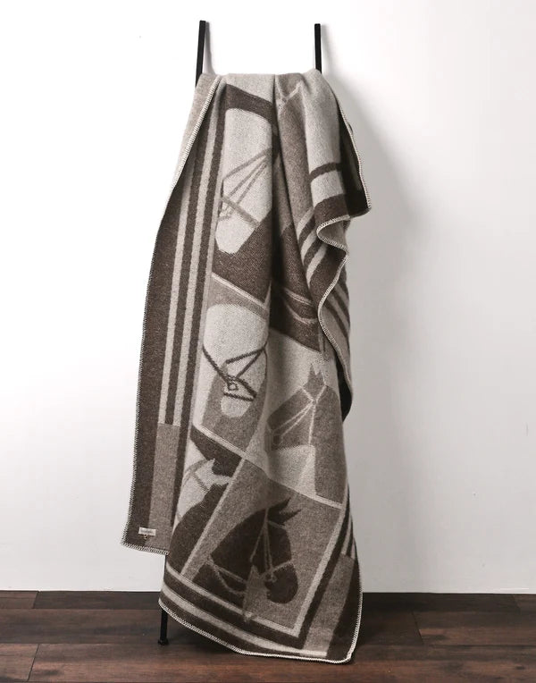 Brown throw with equestrian details on a stand with a white background