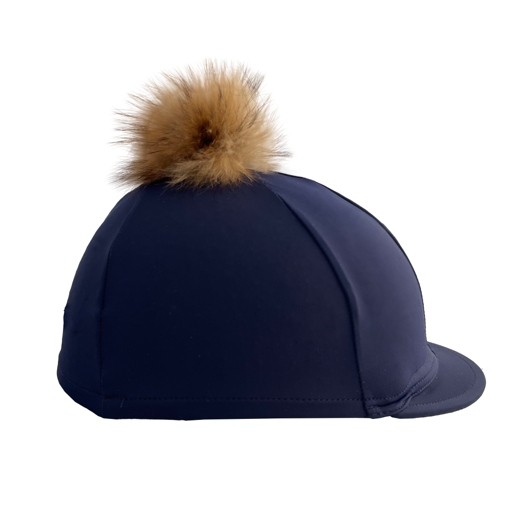 Navy blue riding helmet with a brown fur pom-pom on a white background