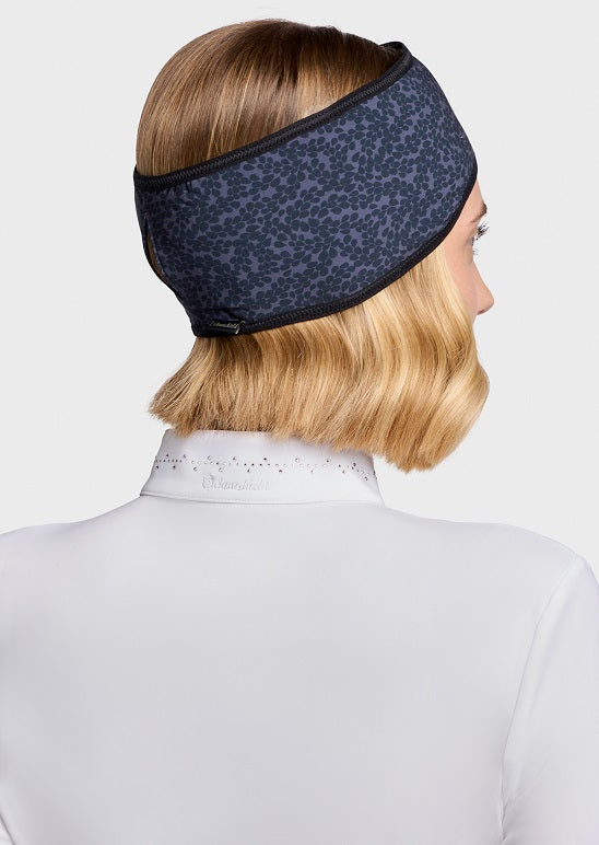 A woman shown from the back wearing a dark navy blue patterned headband with black trim, paired with a white high-neck top, against a light gray background.