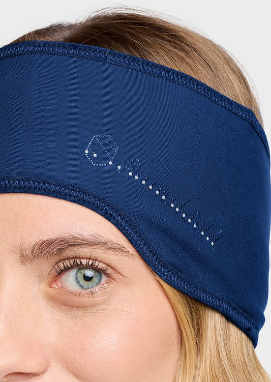 A close-up of a woman wearing a navy blue athletic headband with a white dotted key graphic on the side, set against a light gray background.