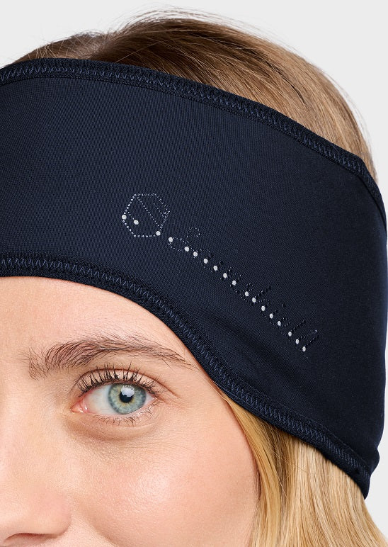 Close-up of a woman wearing a navy athletic headband with a white embroidered logo on the side, set against a light gray background.