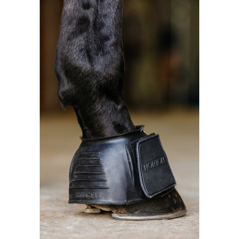 Horse hoof with a black protective boot on a blurred background