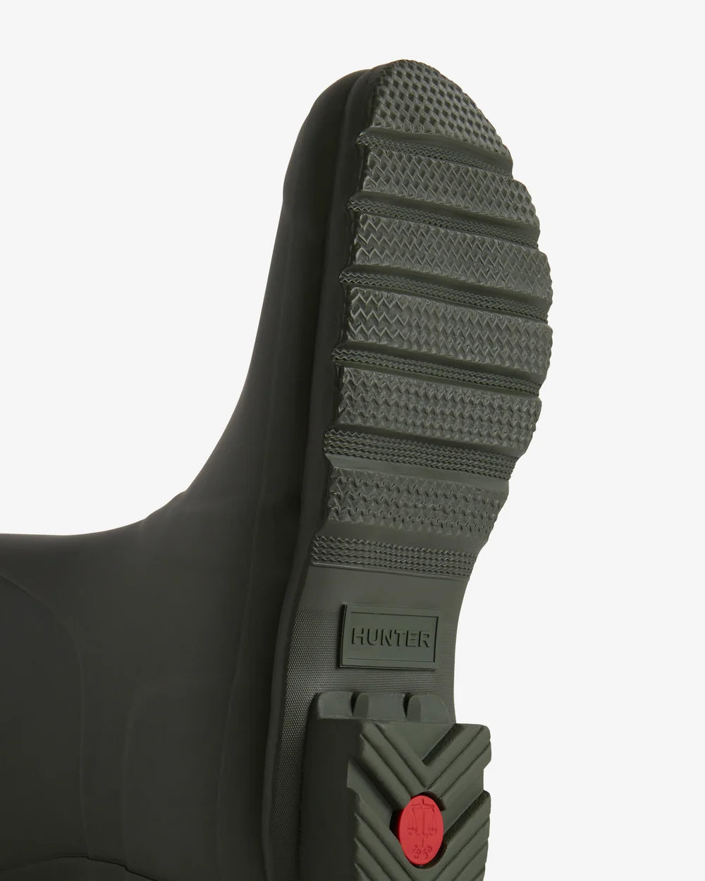Close-up of a black rubber boot sole with a textured pattern on a white background