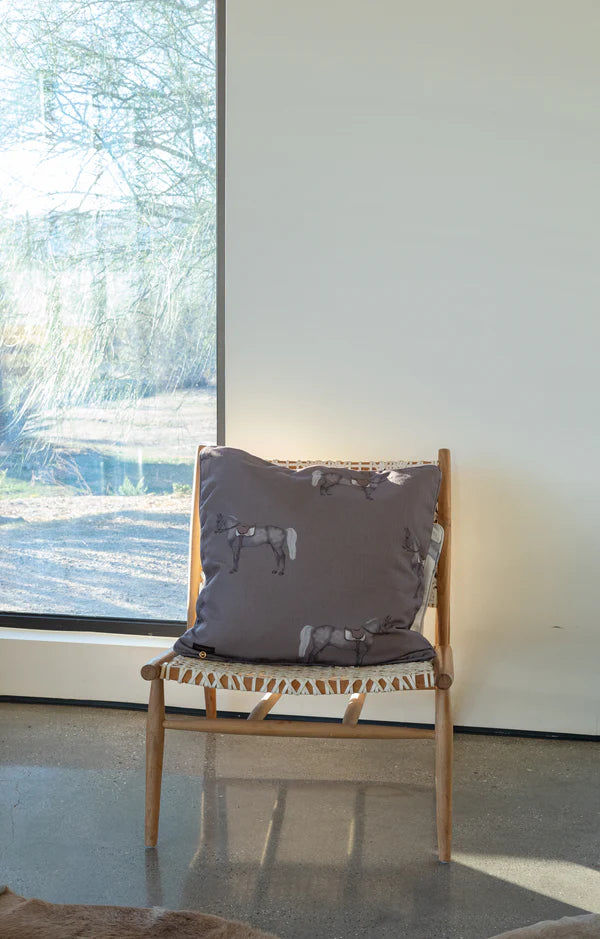 Chair with a decorative pillow in front of a large window