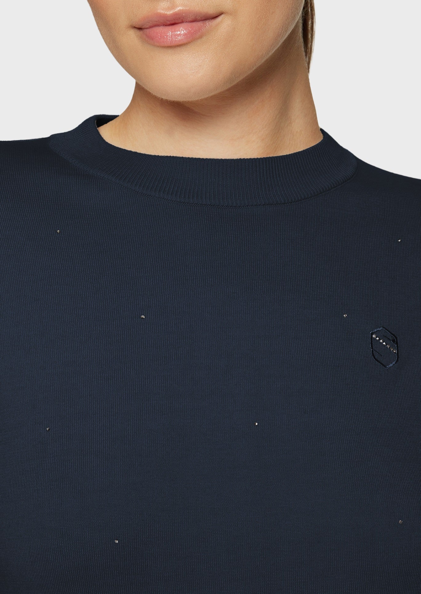 Woman wearing a navy pullover on a beige background