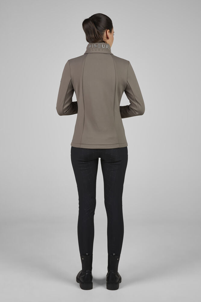 Person wearing a brown jacket and black pants on a gray background