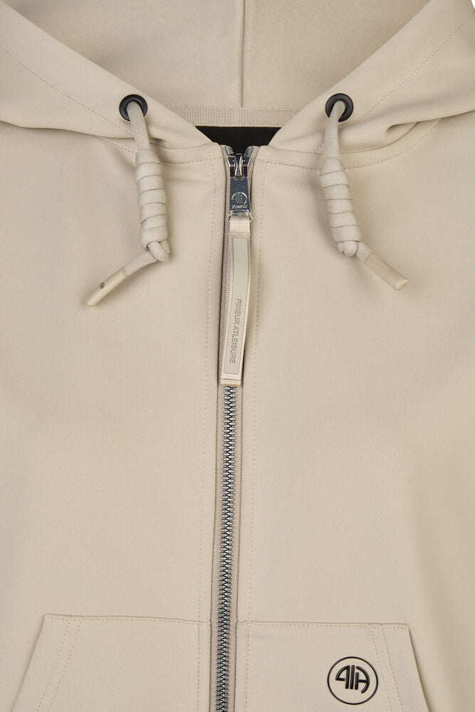 Close-up of a beige hoodie with a zipper on a light beige background