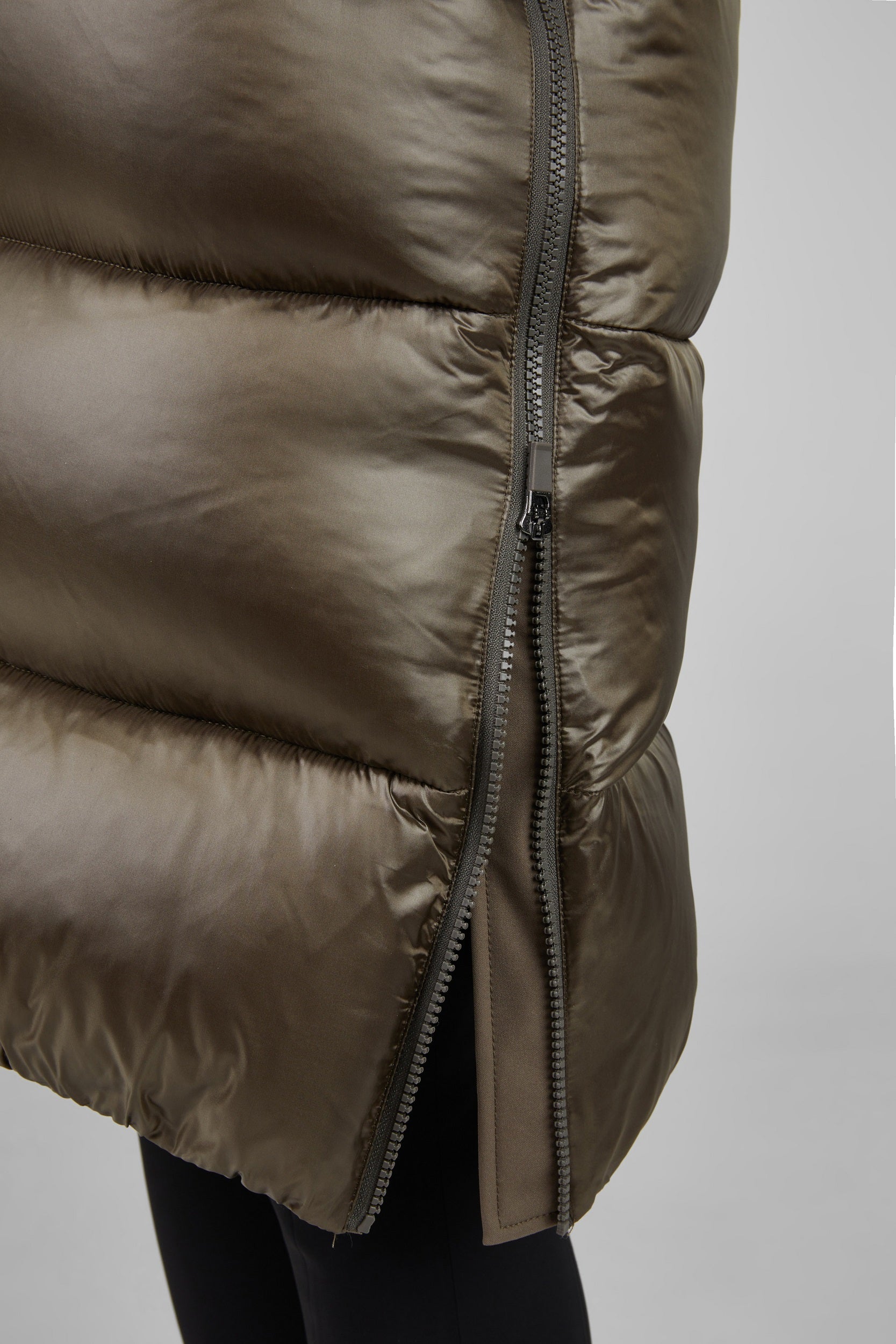 Close-up of a brown puffer jacket with a zipper on a light gray background