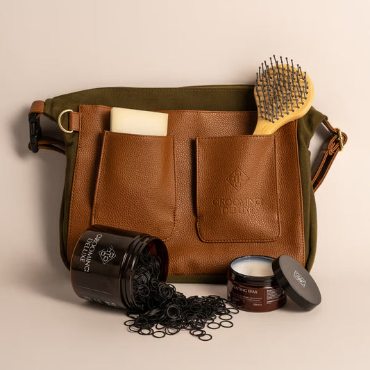 Grooming bag with hair products including a brush, jar, and container on a beige background.