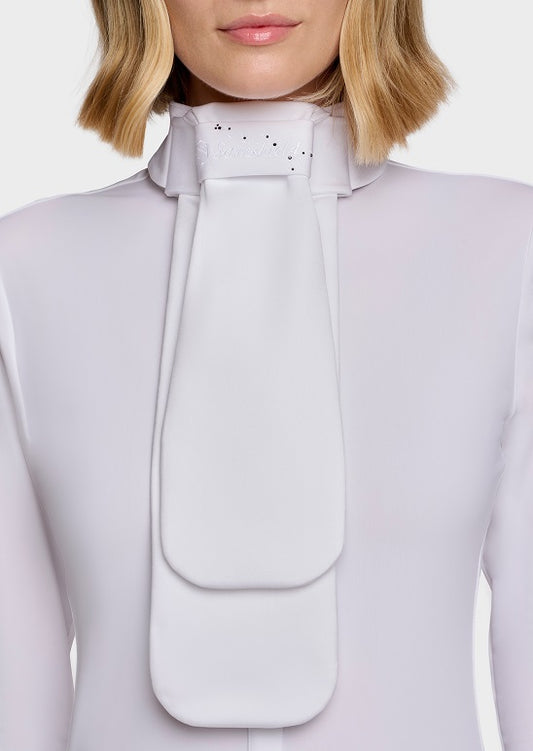 A close-up of a model wearing a high-neck, structured white blouse with a dramatic oversized bow or collar detail at the neck.