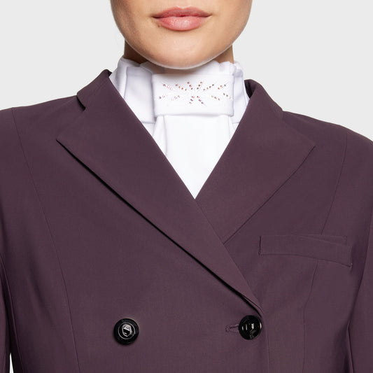 Close-up of a person wearing a purple blazer over a white shirt with a white dressage stock.