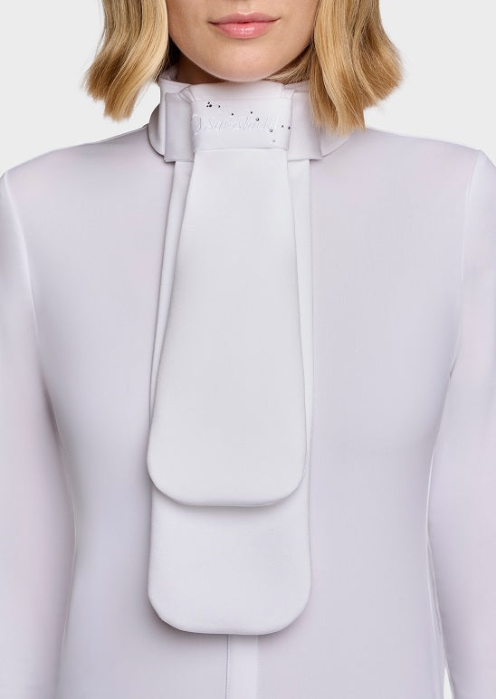 A close-up of a model wearing a white high-neck blouse with a large, structured bow tie detail at the collar.