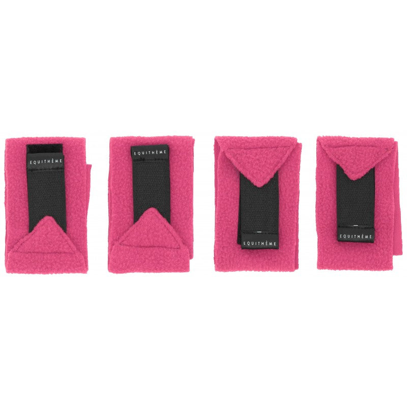 Four bright pink fleece horse blankets with black elastic straps and Loughnane brand labels, arranged in a row on a white background.