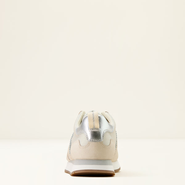 White sneaker with a metallic silver heel on a light beige background