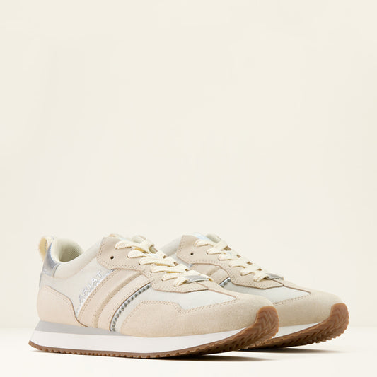 Beige sneakers with brown sole on a light beige background