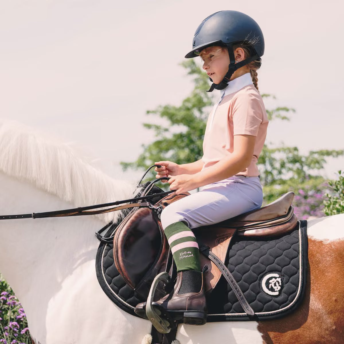 Young girl sitting on a skewbald pony