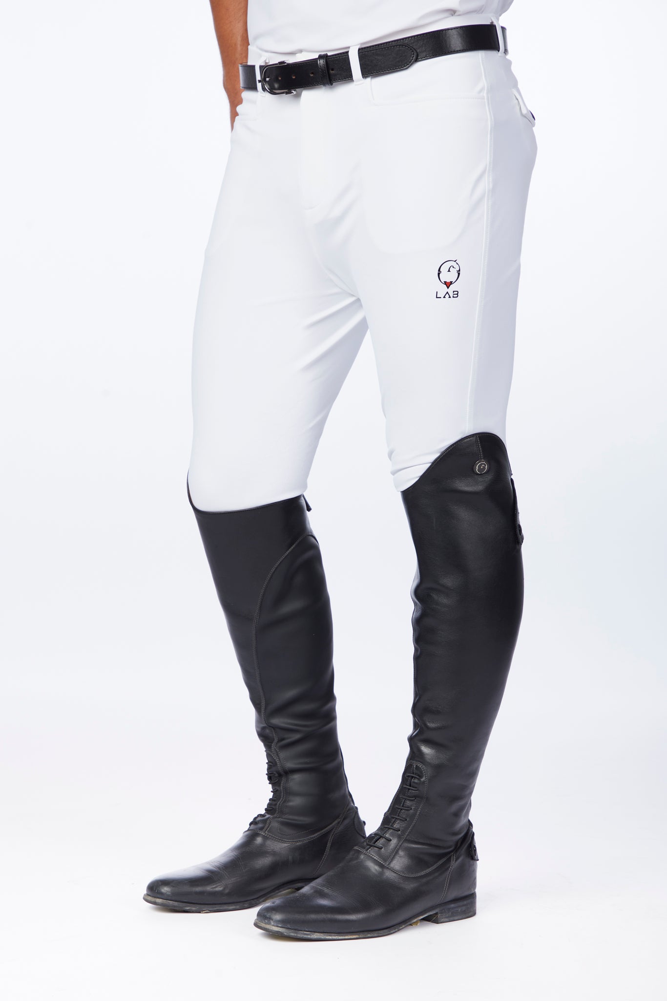 White riding pants with black long riding boots worn by a person on a white background