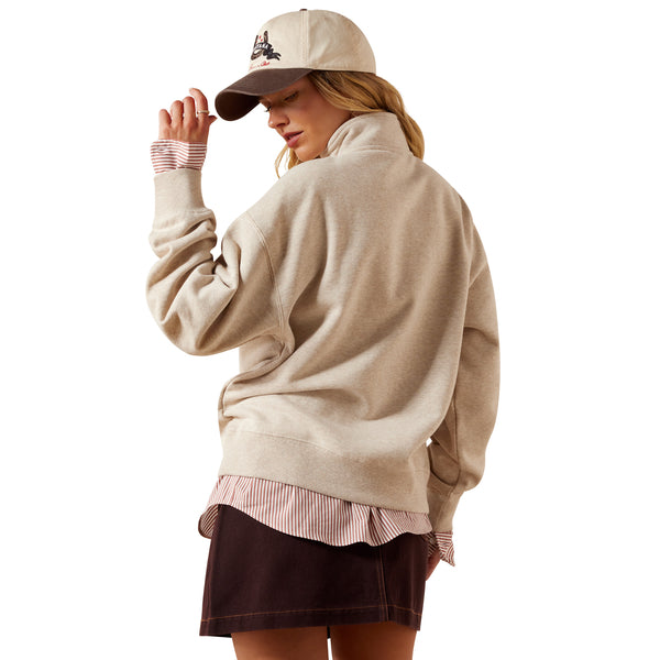Woman wearing a beige sweatshirt, cap, and skirt on a white background
