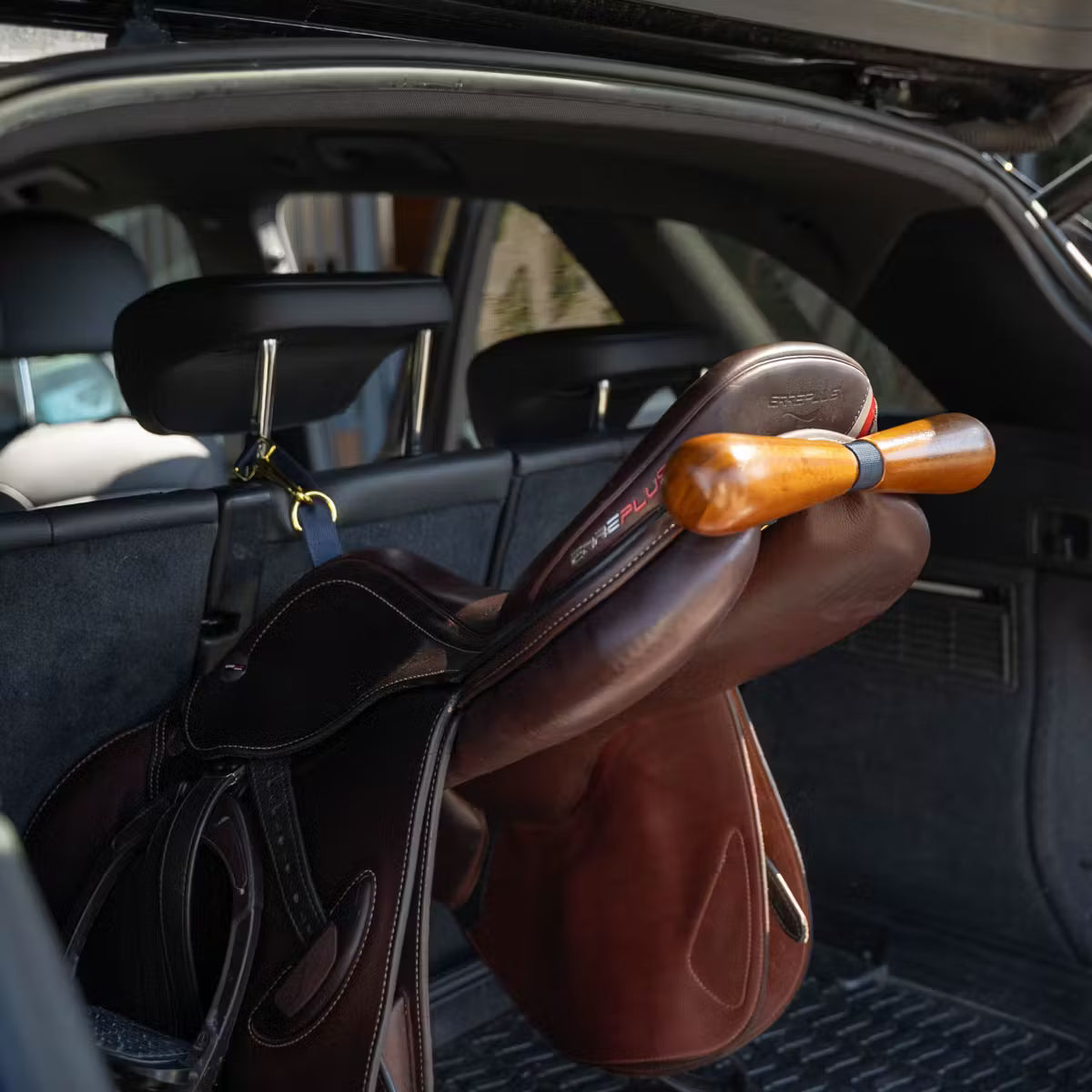 Brown leather saddle in a car trunk