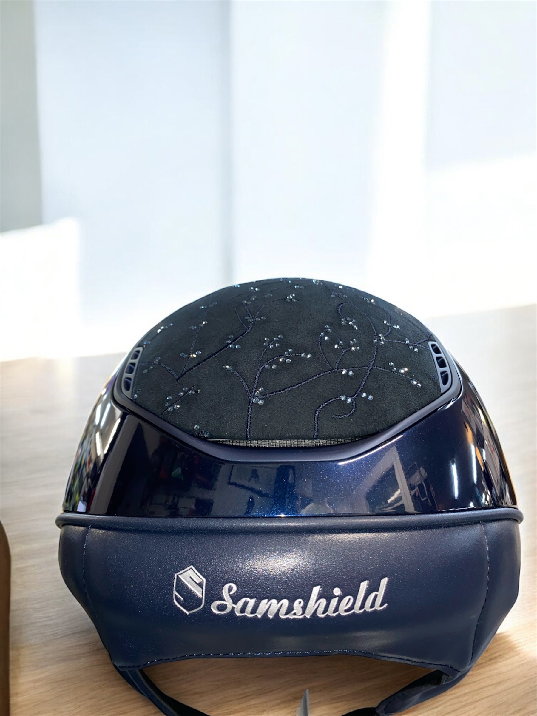 Blue Samshield equestrian helmet on a wooden surface with a blurred background