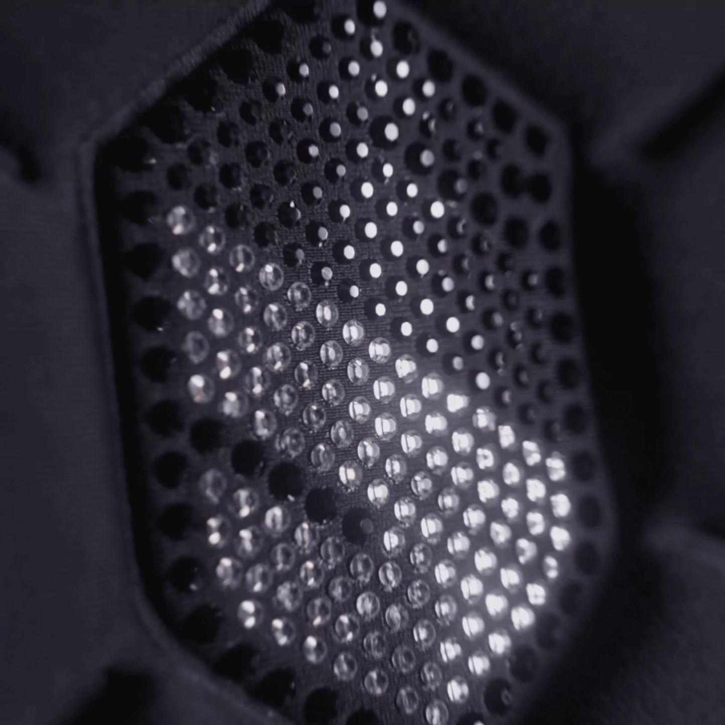 Close-up of a black Samshield crystal logo with light diffusing through it