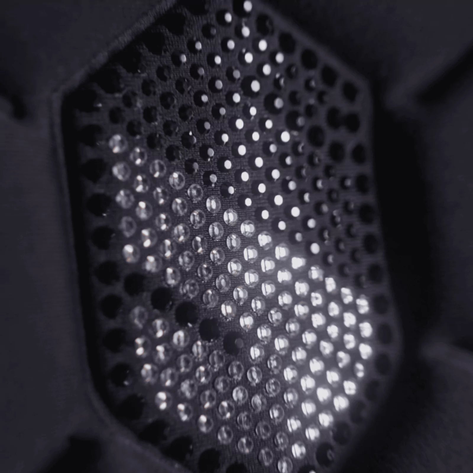 Close-up of a black Samshield crystal logo with light diffusing through it