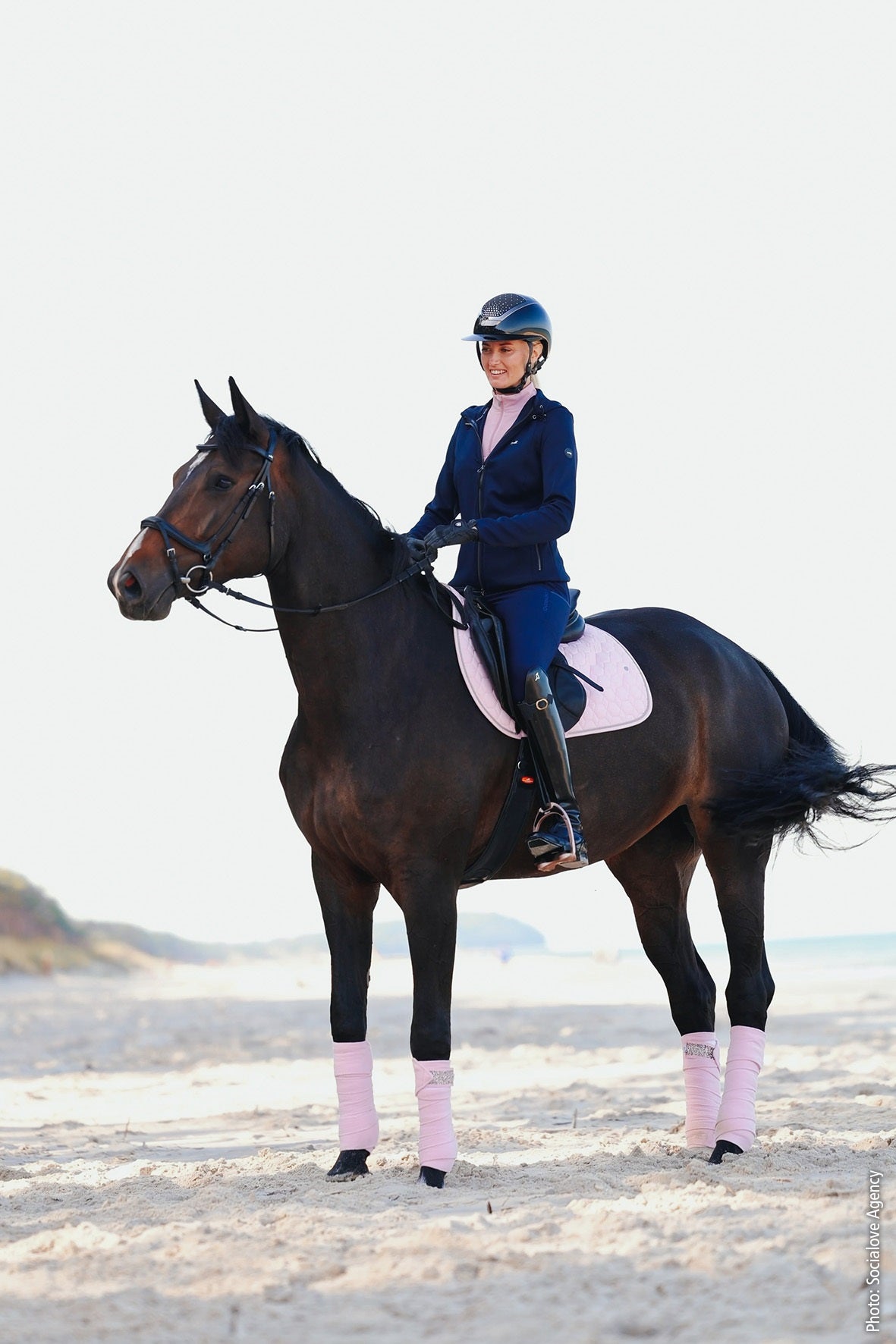 Person riding a horse on a sandy beach