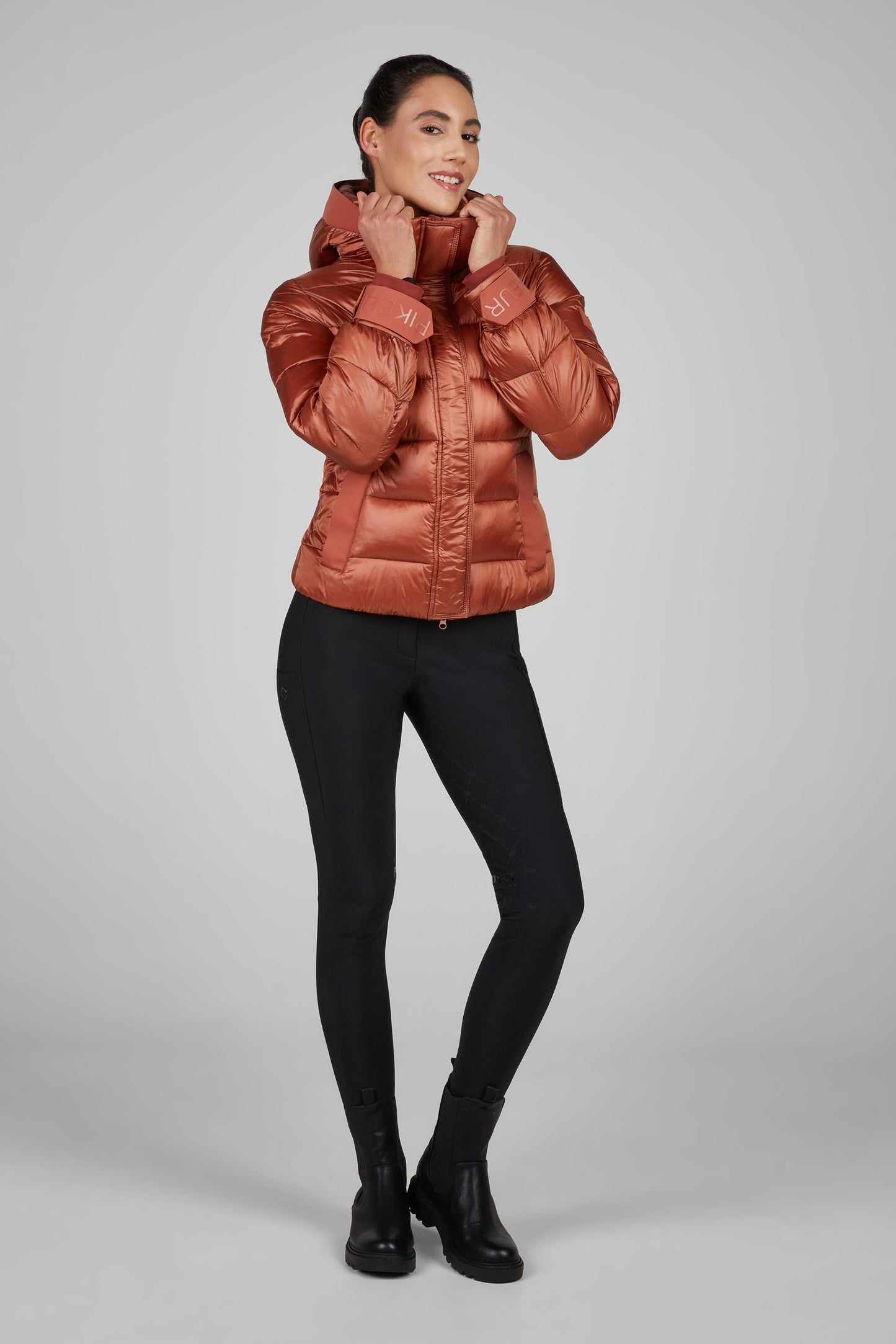 Woman wearing a red puffer jacket on a gray background