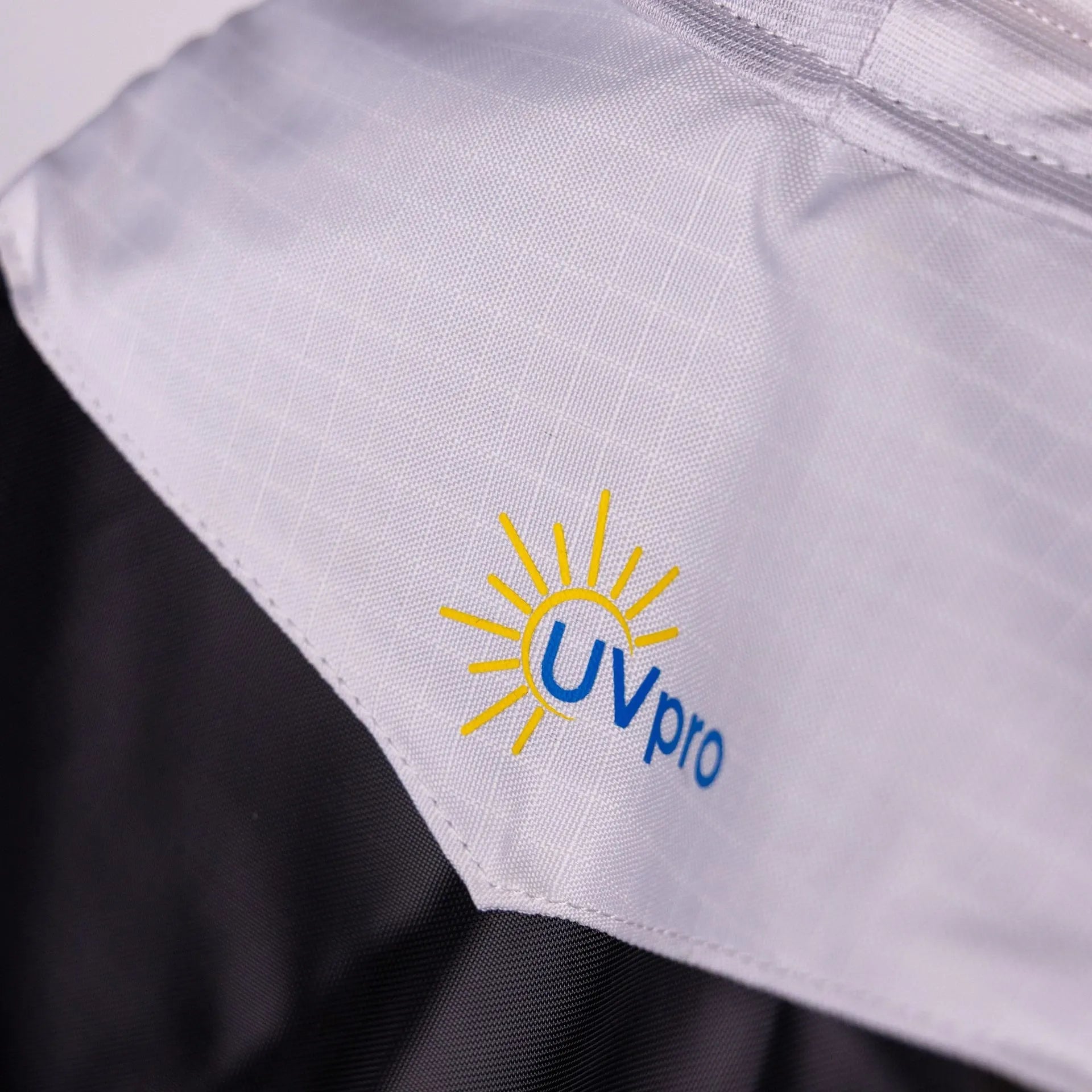 Close-up of a fabric with UVpro logo on a gray background
