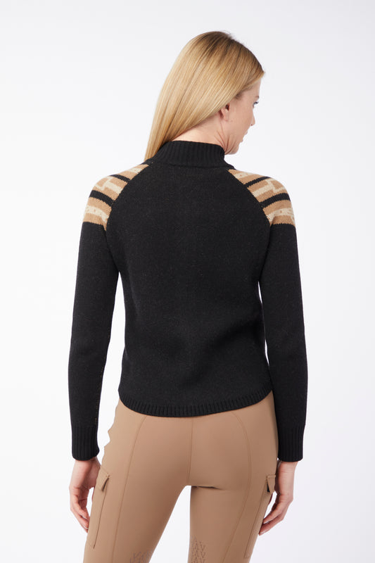 Woman wearing a black sweater with beige accents on a white background