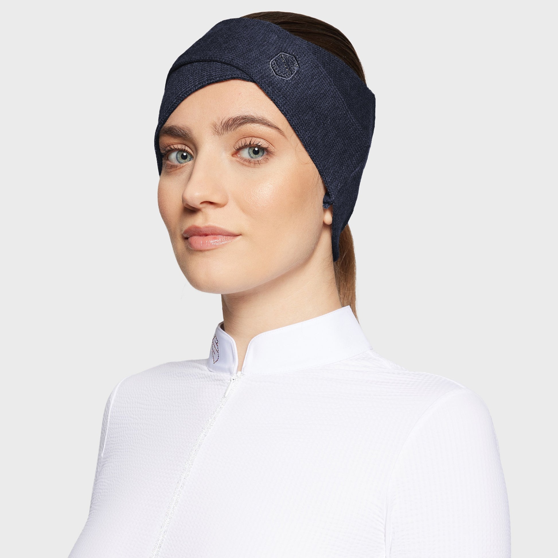 Woman wearing a navy criss-cross headband with glitter