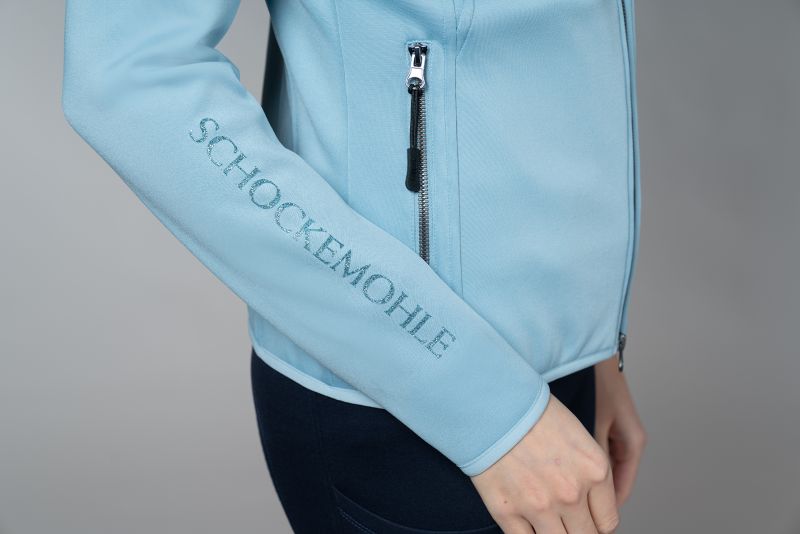 Close up of sleeve with Schockemohle writing in glitter on the sleeve on a grey background