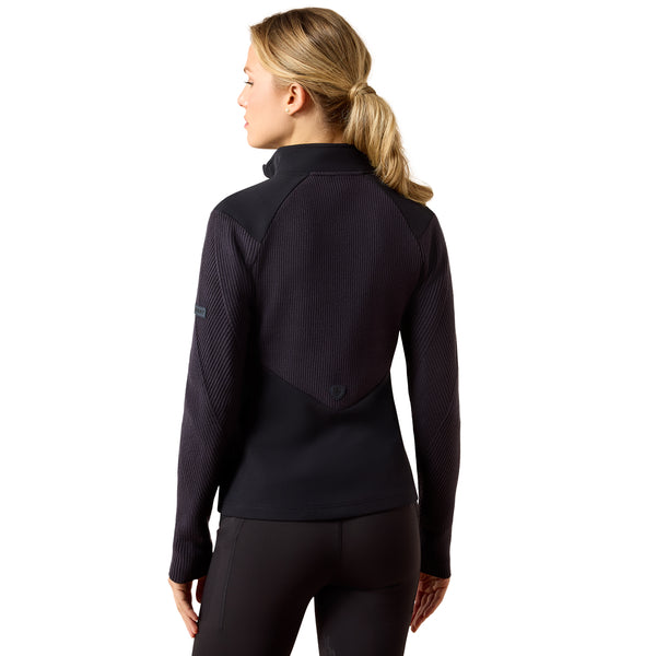 A woman shown from the back wearing a navy long-sleeve athletic quarter-zip pullover with textured knit sleeves and a smooth back panel, paired with black leggings, against a plain white background.
