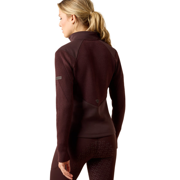 A woman shown from the back wearing a dark burgundy athletic quarter-zip fleece and matching leggings against a plain white background.