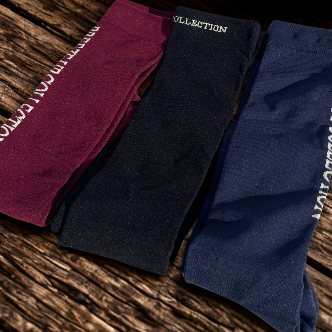 Three pairs of socks in maroon, black, and navy on a wooden surface.
