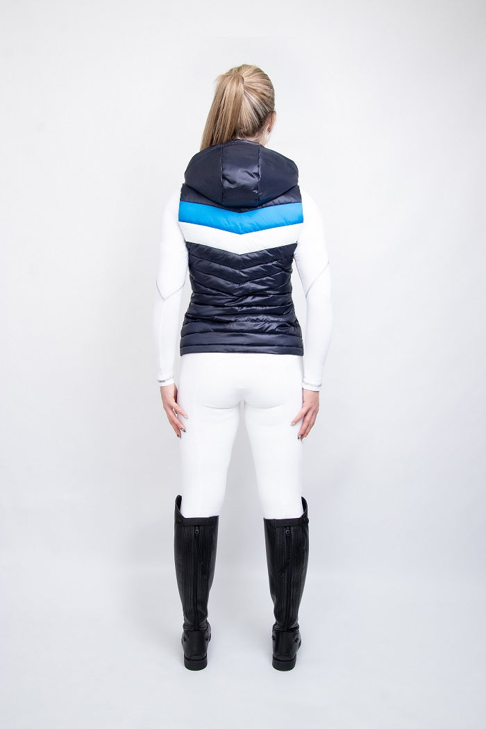 Woman wearing a navy, blue and white gilet and white breeches on a white background